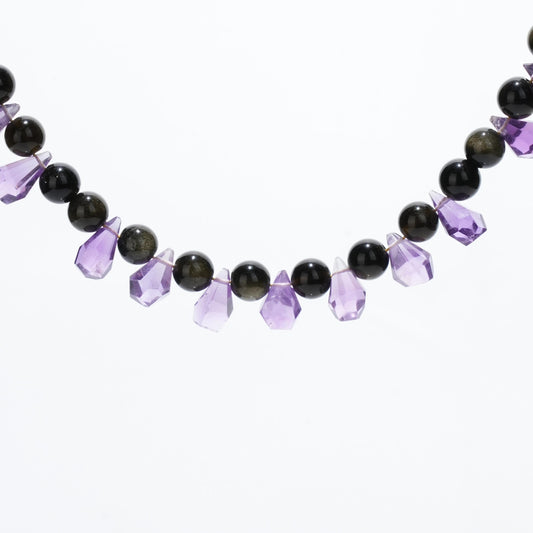 This stunning necklace features a beautifully faceted teardrop Amethyst, known for its ability to enhance clarity and intuition, paired with Golden Obsidian to provide grounding and protection.