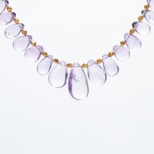 Featuring a stunning teardrop-shaped Lavender Amethyst known for its calming and spiritual properties, this necklace is accented with elegant 18K gold spacer beads to create a harmonious blend of luxury and healing energy.